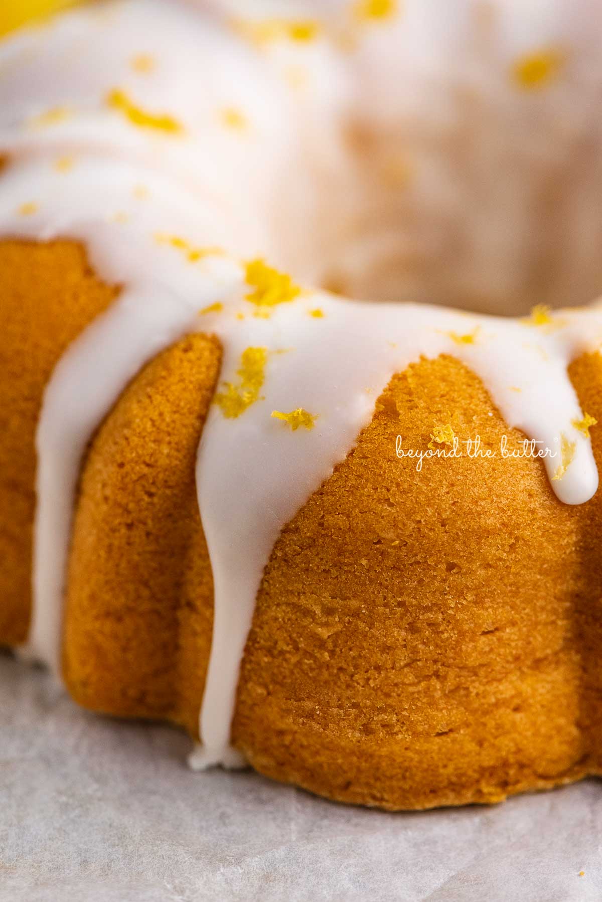 Close up image of lemon glazed small lemon cream cheese pound cake garnished with lemon zest | © Luyiz®