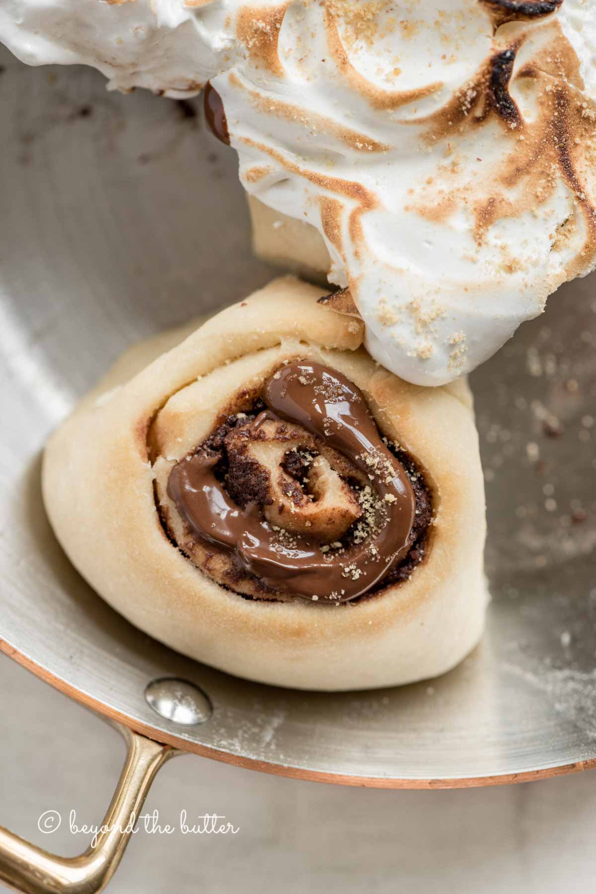Overhead closeup image of s'mores rolls partially covered with marshmallow topping | All Images © Luyiz™