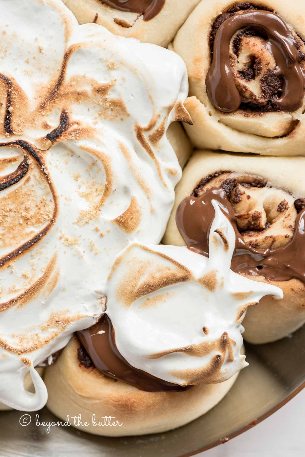 Overhead closeup image of s'mores rolls partially covered with marshmallow topping | All Images © Luyiz™