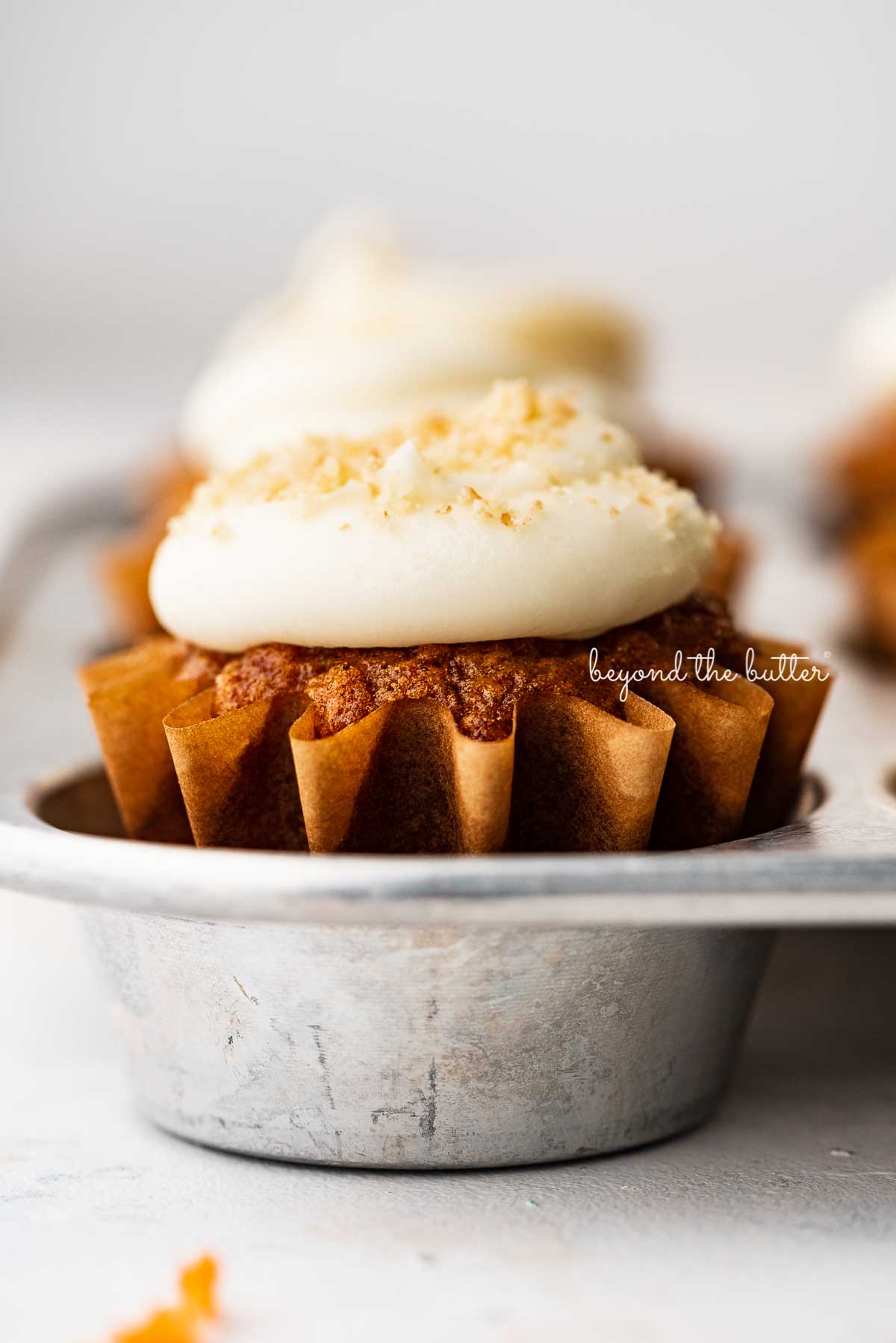 Closeup image of carrot cake cupcakes in a vintage cupcake tin | © Luyiz®