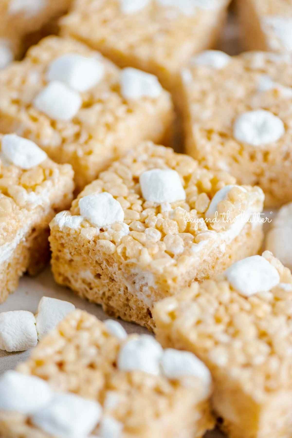 Rice krispie treats randomly placed on wax paper with a few mini marshmallows in between.