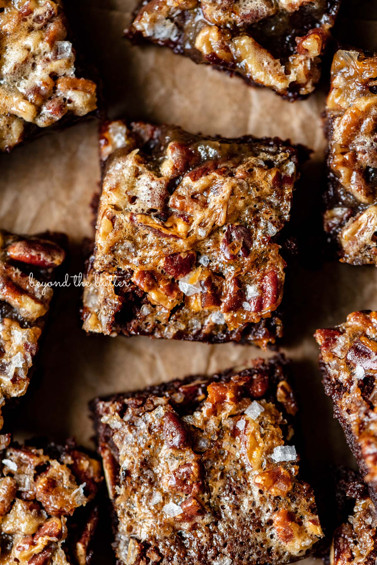 Salted pecan pie brownies placed on brown parchment paper | © Luyiz®