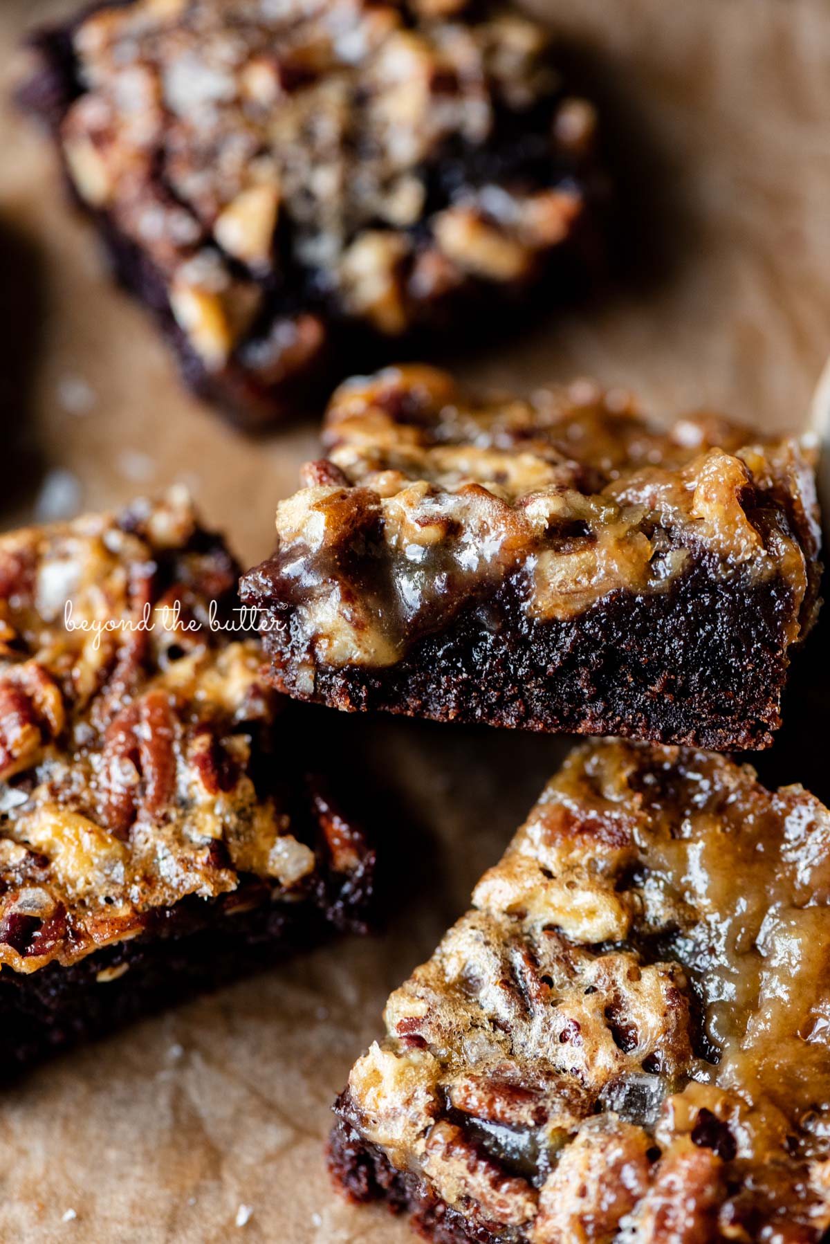 Salted pecan pie brownies placed on brown parchment paper | © Luyiz®