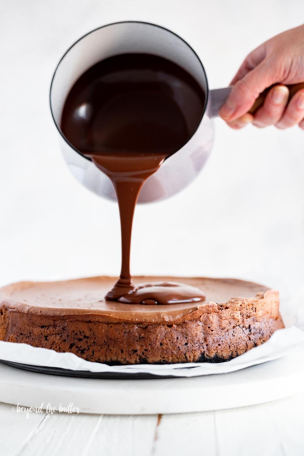Pouring dark chocolate ganache over top of Triple Chocolate Mocha Cheesecake | All Images © Luyiz, LLC