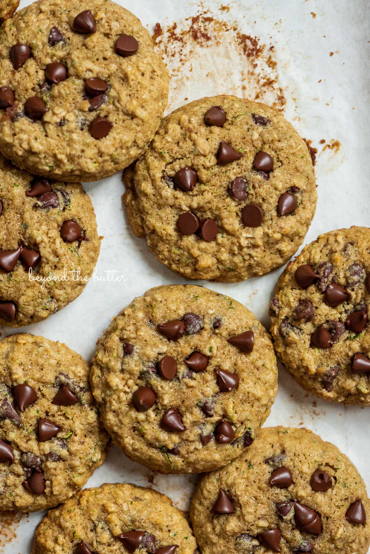 Zucchini chocolate chip oatmeal cookies on a parchment paper lined baking sheet from Luyiz | © Luyiz®