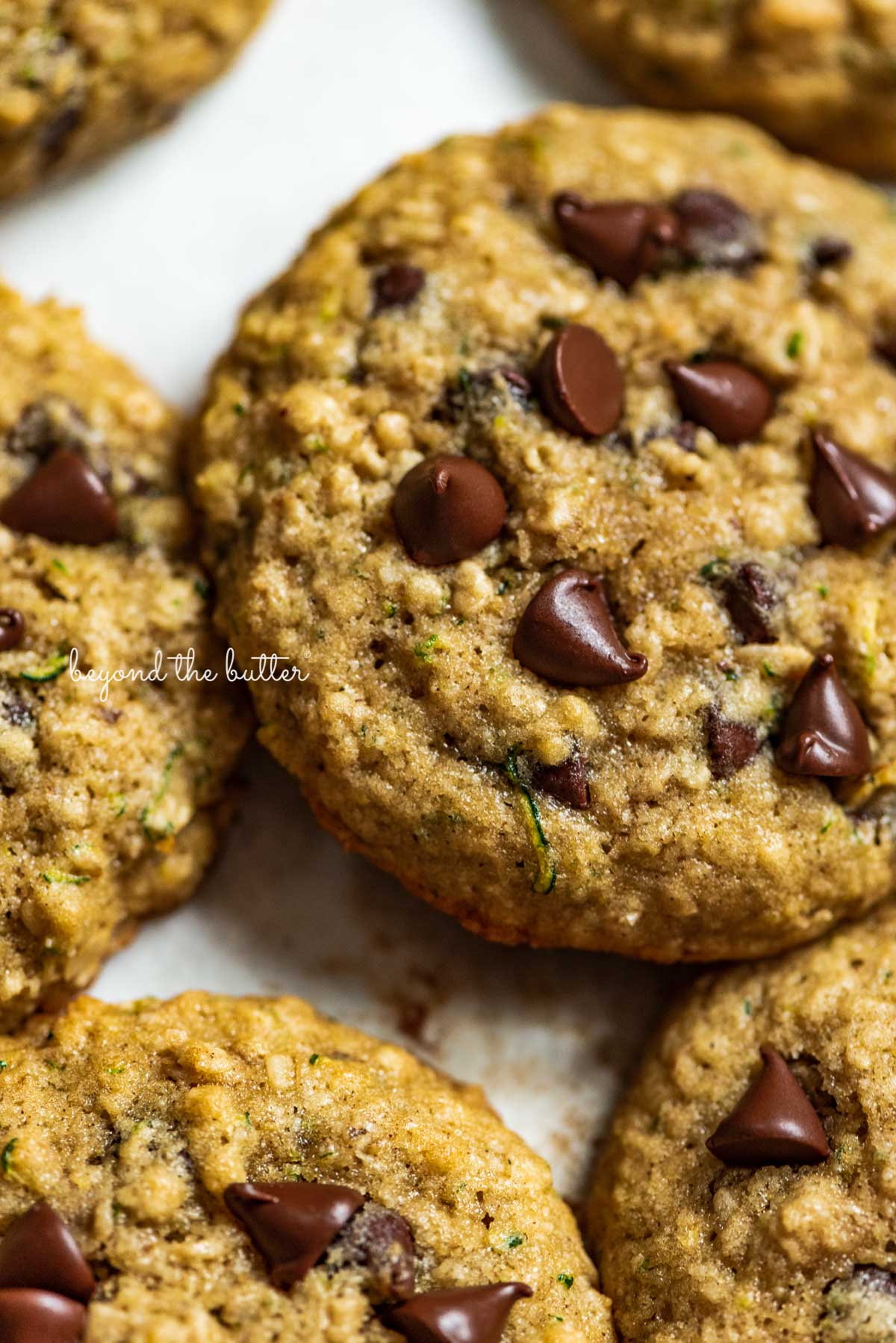 Zucchini chocolate chip oatmeal cookies on a parchment paper lined baking sheet from Luyiz | © Luyiz®