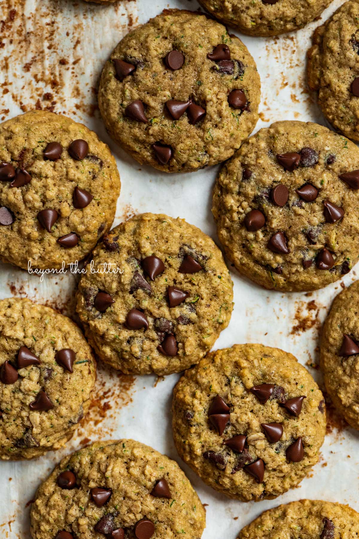 Zucchini chocolate chip oatmeal cookies on a parchment paper lined baking sheet from Luyiz | © Luyiz®