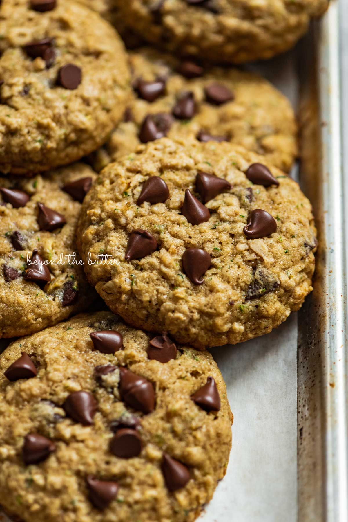 Zucchini chocolate chip oatmeal cookies on a parchment paper lined baking sheet from Luyiz | © Luyiz®