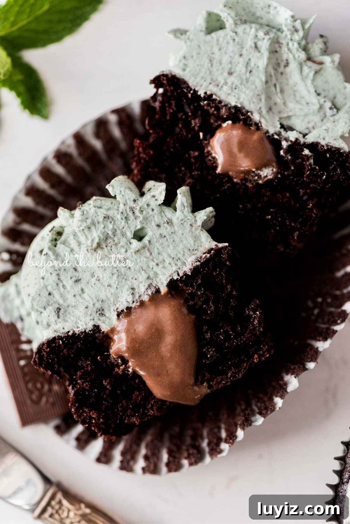 Mint Chocolate Cupcake Recipe: Moist Chocolate Cakes with Minty Frosting 4 Sliced inside shot of mint chocolate cupcakes with mint chocolate ganache filling placed on an open cupcake liner.