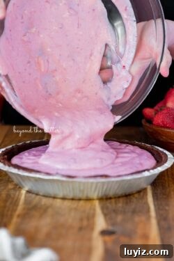 No-Bake Chocolate Strawberry Pie Recipe for Summer Parties 9 Pouring the strawberry pie filling mixture into the prepared Diamond of CA® chocolate nut pie crust | All images © Beyond the Butter®