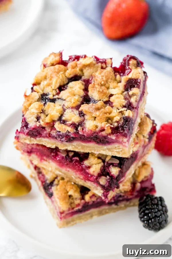 Mixed Berry Crumble Bars Recipe — Quick Fruit Dessert Bars 5 Overhead view of 3 mixed berry oatmeal crumble bars stacked on top of each other.