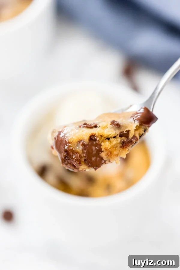 Quick Chocolate Chip Mug Cookie: Ready in Minutes 4 A spoonful of a warm chocolate chip cookie that's made in a mug with melted chocolate chips.