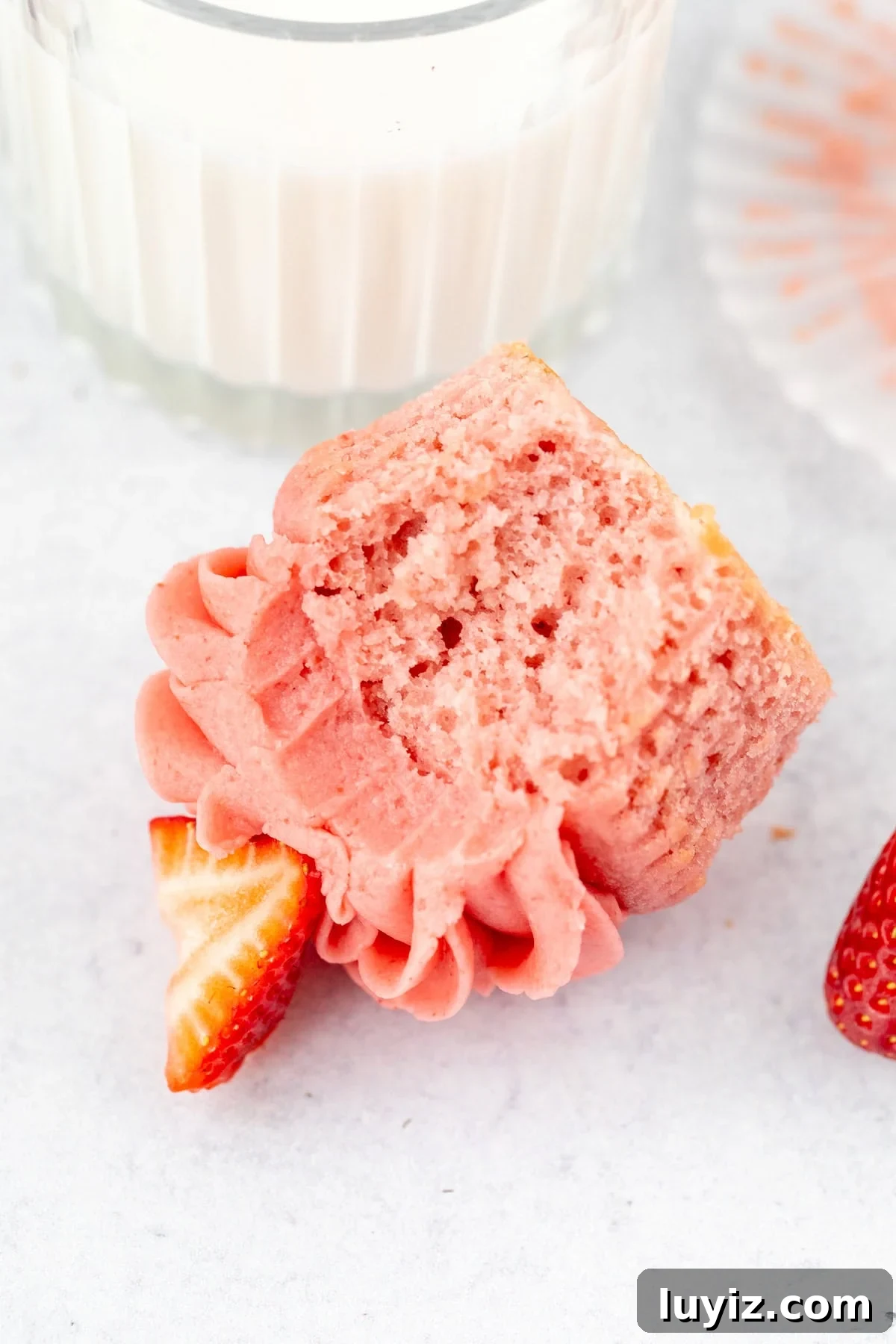 Moist Strawberry Cupcakes with Fresh Strawberry Frosting 11 Strawberry cupcake with strawberry buttercream with a bite taken out