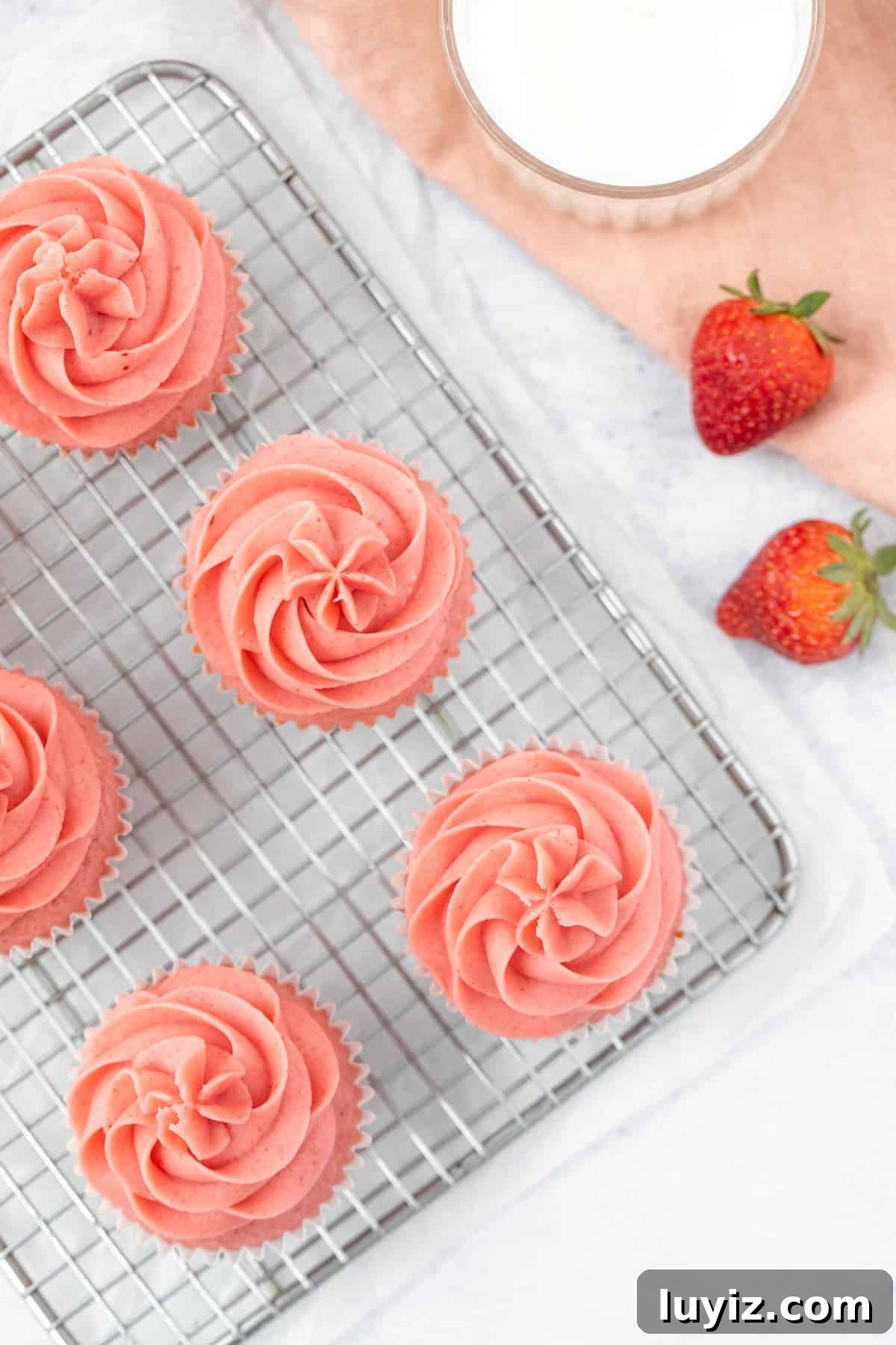 Moist Strawberry Cupcakes with Fresh Strawberry Frosting 10 strawberry cupcakes piped with strawberry frosting on a cooling rack