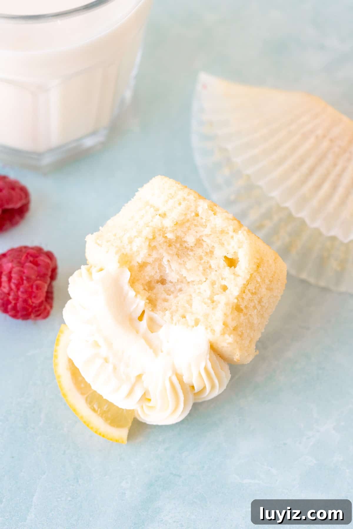 Zesty Lemon Cupcakes with Luscious Lemon Buttercream Frosting 5 Lemon cupcake with bite taken out, on its side