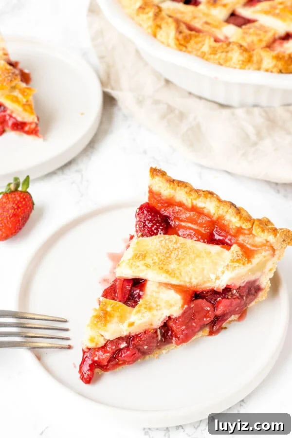 Classic Fresh Strawberry Pie Recipe for Summer Gatherings 5 A slice of baked strawberry pie with lattice crust on top and a juicy berry pie filling.