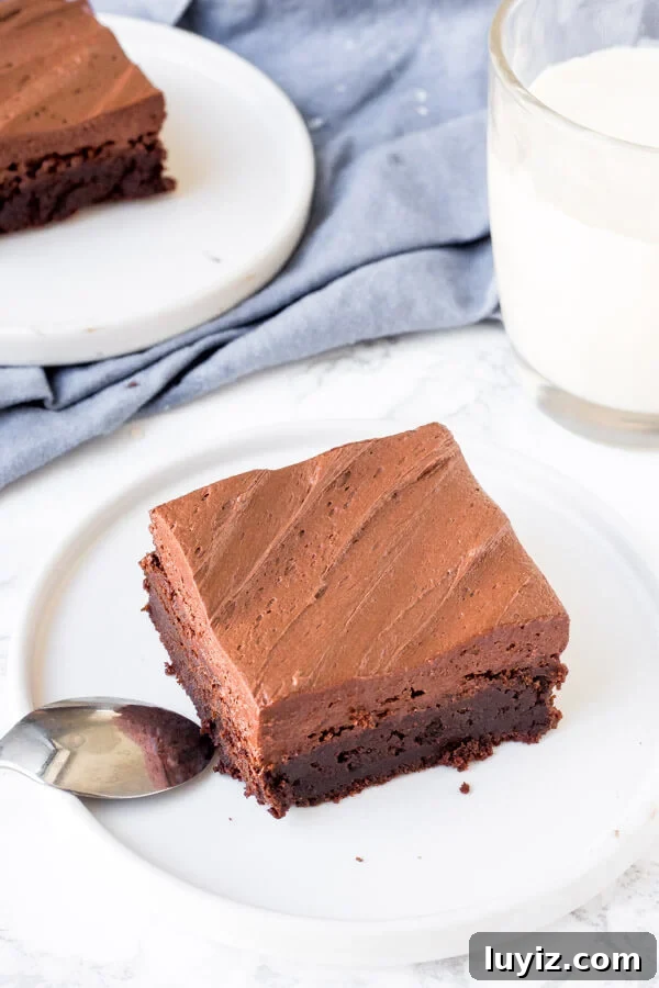 Decadent Chocolate Frosting for Brownies: Smooth, Rich & Quick 5 A brownie topped with chocolate brownie frosting with a glass of milk.