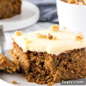 Moist Zucchini Cake Recipe with Cinnamon and Walnuts 5 This moist, tender zucchini cake is filled with spices and topped with cream cheese frosting.
