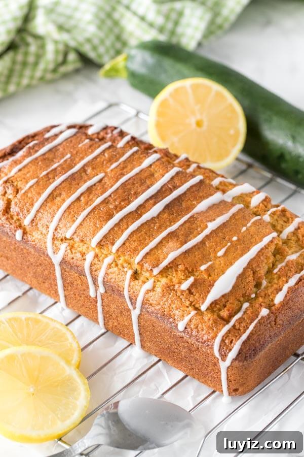 Moist Lemon Zucchini Bread with Citrus Glaze 3 Fresh out of the oven lemon zucchini bread with a drizzle of lemon glaze on a cooling rack
