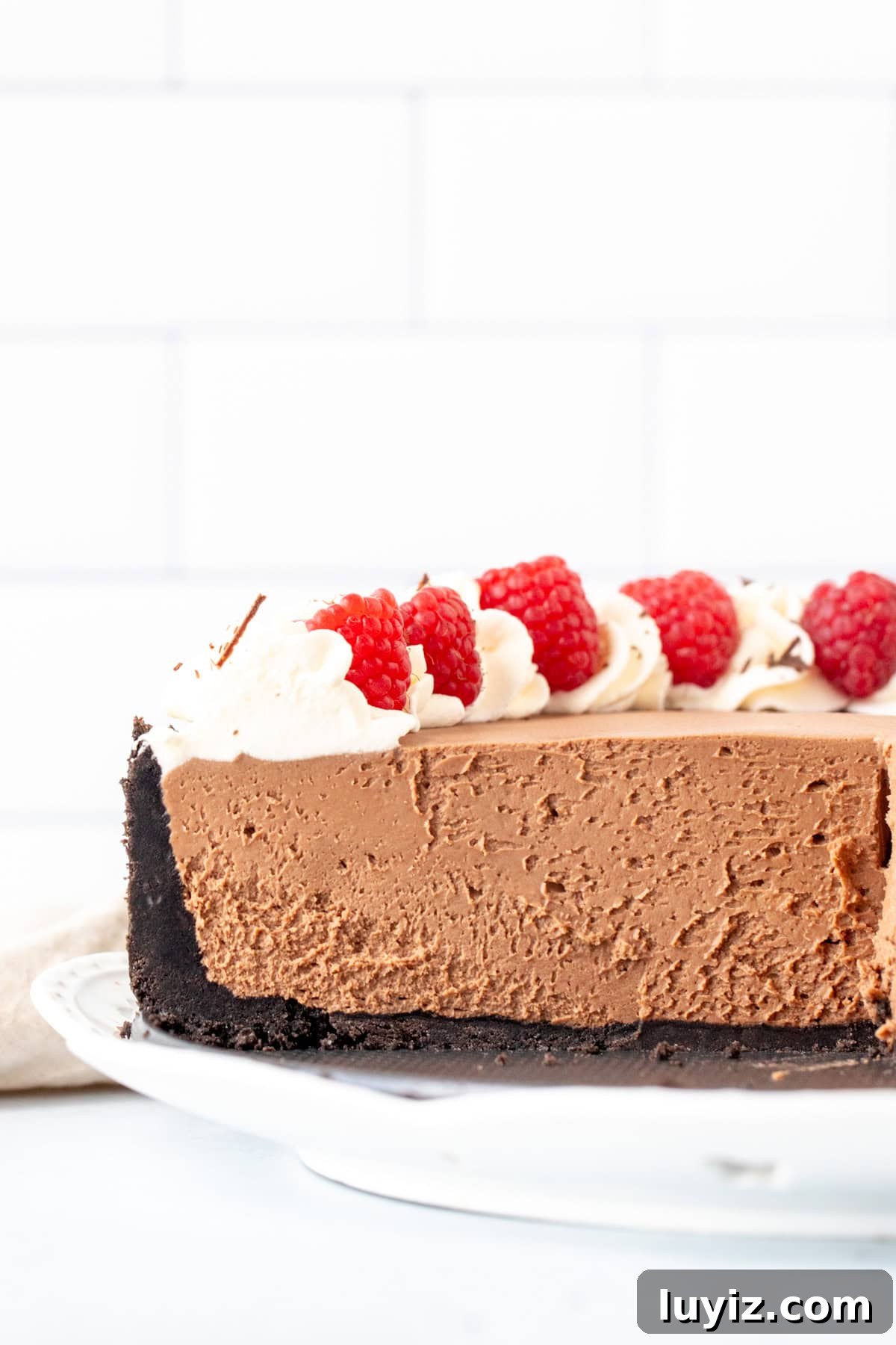 Creamy No-Bake Chocolate Cheesecake Recipe 9 Half of a no bake chocolate cheesecake with an Oreo crust decorated with berries and whipped cream