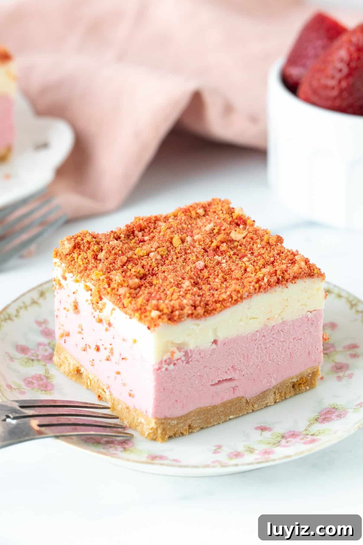 Strawberry Shortcake Ice Cream Cake Recipe — No-Bake Dessert 7 Slice of layered strawberry shortcake ice cream cake with strawberry crunch topping on a plate.
