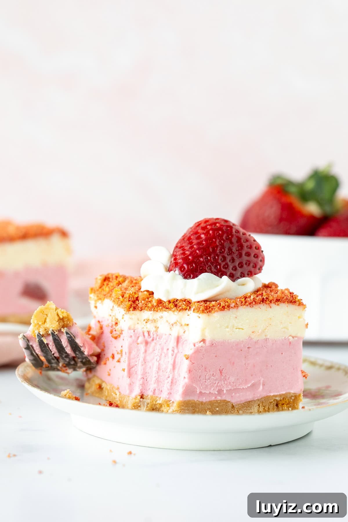 Strawberry Shortcake Ice Cream Cake Recipe — No-Bake Dessert 8 Slice of strawberry crunch ice cream cake on a plate with a bite taken out.
