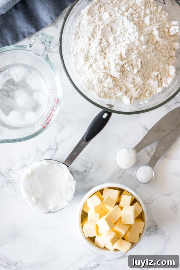 Perfect Flaky Pie Crust Recipe for Homemade Pies 3 Overhead shot of ingredients for making this pie crust recipe: cubed butter, shortening, flour, salt, sugar and ice water.