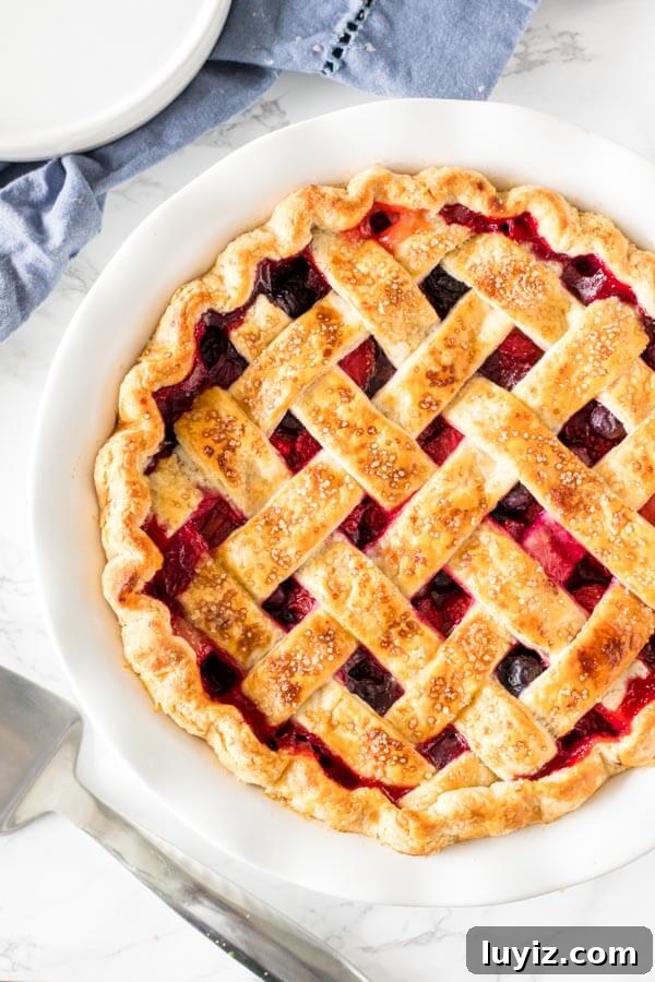 Mixed Berry Pie Recipe: Homemade Rustic Summer Fruit Tart 5 Mixed berry pie with a golden brown lattice crust and crimped edges fresh from the oven.