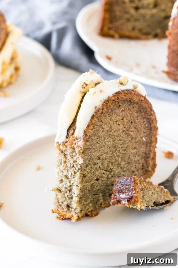 Moist Banana Bundt Cake Recipe with Cinnamon Glaze 5 A slice of banana cake with a bite taken out of it to show the moist, tender texture.