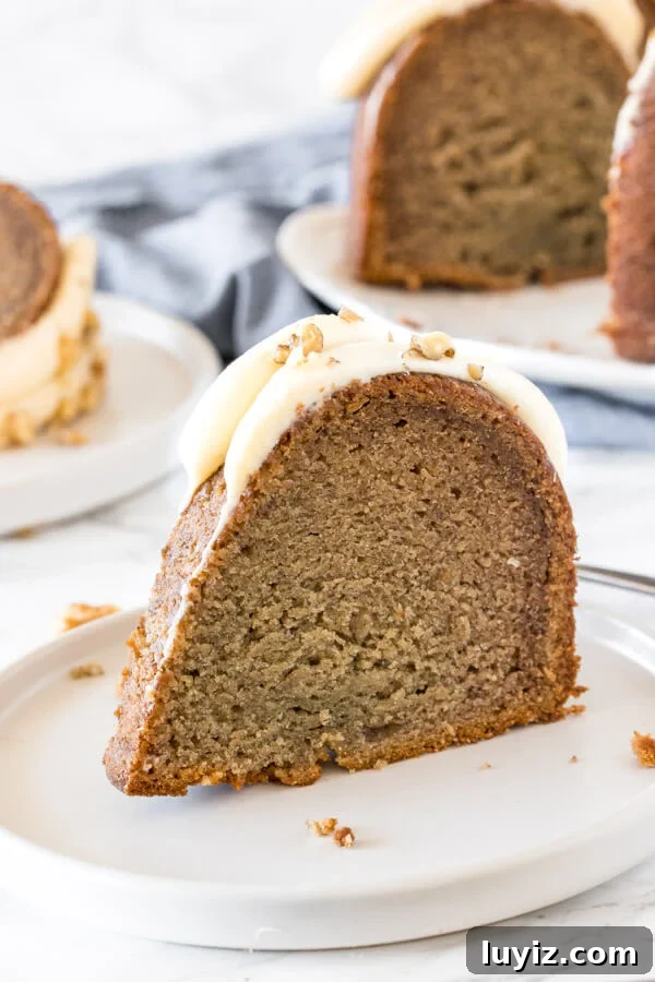 Perfect Bundt Cake: Tips for Moist, Even Baking Every Time 5 A slice of banana bundt cake with cream cheese frosting on a white plate.