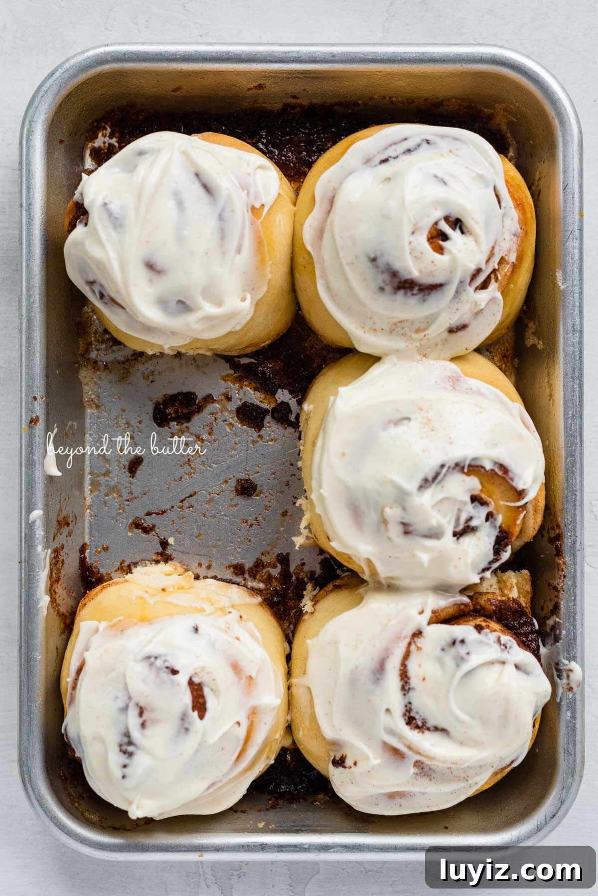 Small-Batch Cinnamon Rolls Recipe for Two to Four People 9 Just frosted small batch cinnamon rolls with one already eaten from BeyondtheButter.com | © Beyond the Butter®