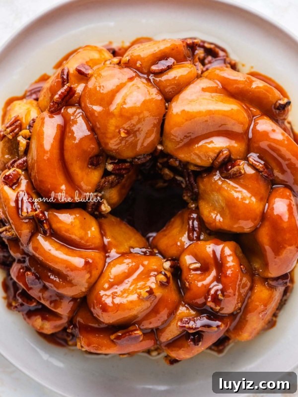 Strawberry-Glazed French Crullers Recipe for Homemade Pastries 10 Overhead view of butterscotch bundt rolls on white dessert plate and white background.