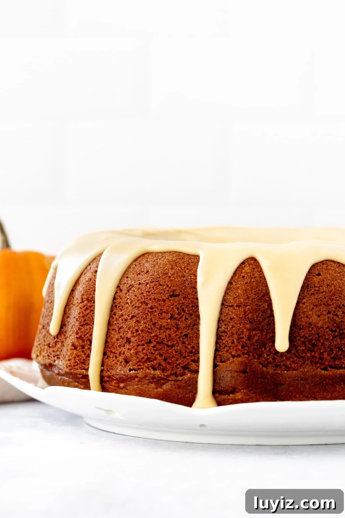 Moist Pumpkin Bundt Cake with Warm Spice Glaze 7 9-inch round pumpkin bundt cake with maple glaze poured over top