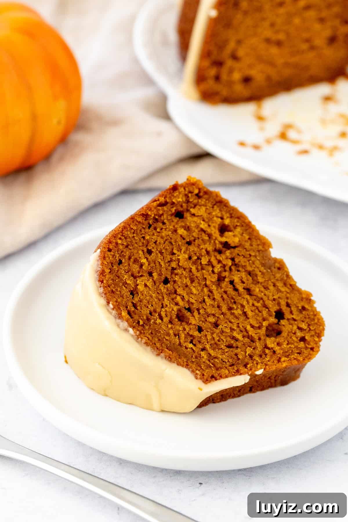 Moist Pumpkin Bundt Cake with Warm Spice Glaze 8 Slice of moist pumpkin bundt cake with maple glaze on top