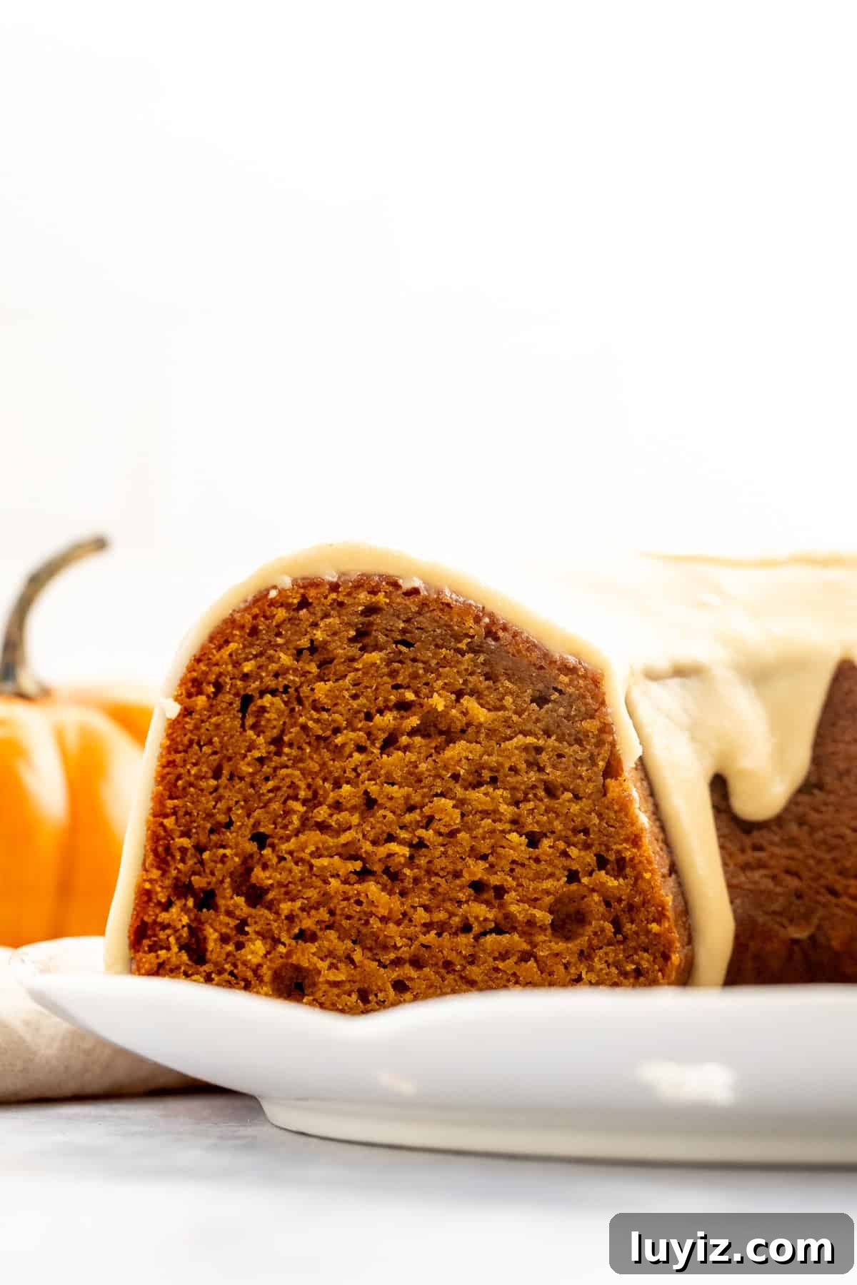 Moist Pumpkin Bundt Cake with Warm Spice Glaze 9 Cross section of a pumpkin bundt cake with glaze