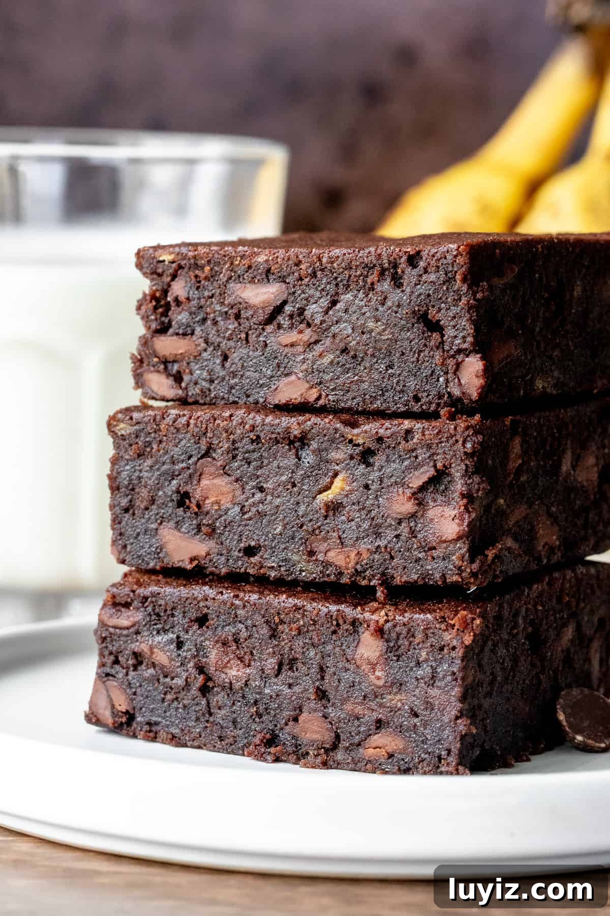 Super Moist Banana Brownies Recipe for Ultra-Fudgy Results 2 3 banana brownies stacked on top of each other with glass of milk