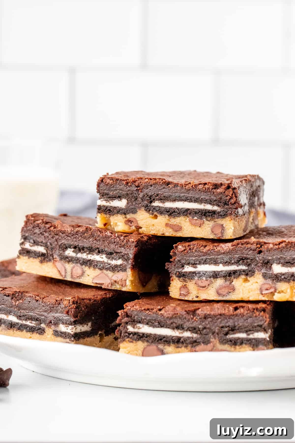 Decadent Fudgy Brownies with Gooey Cookie Layer 3 Plate of layered brownies showing chocolate chip cookie base, Oreos and a fudgy brownie top