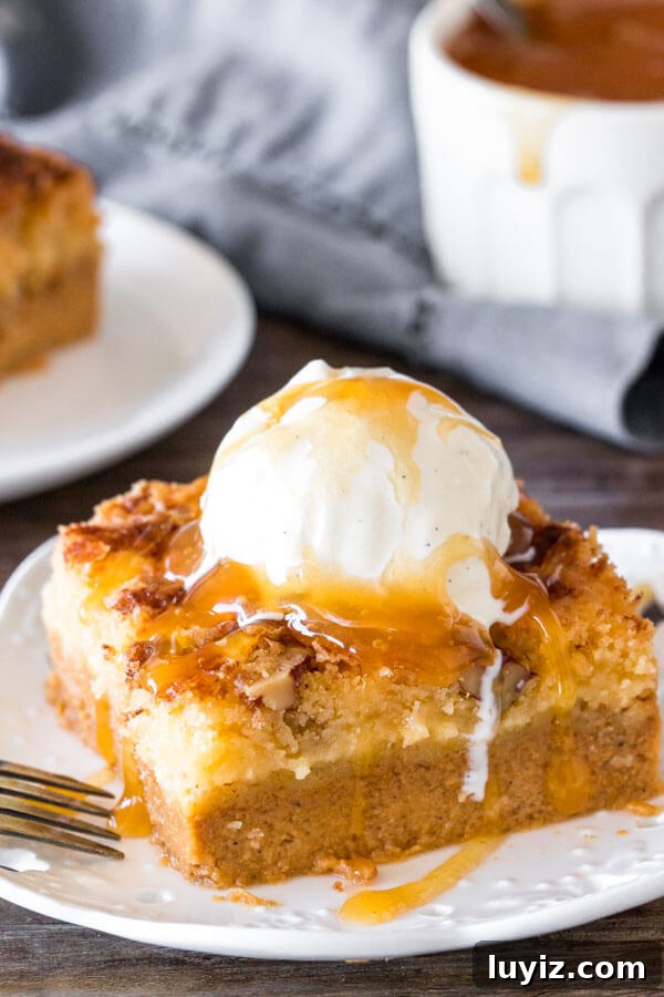 Irresistible Pumpkin Dump Cake Recipe for Fall Baking 2 A slice of pumpkin dump cake with a scoop of ice cream and caramel sauce on top.