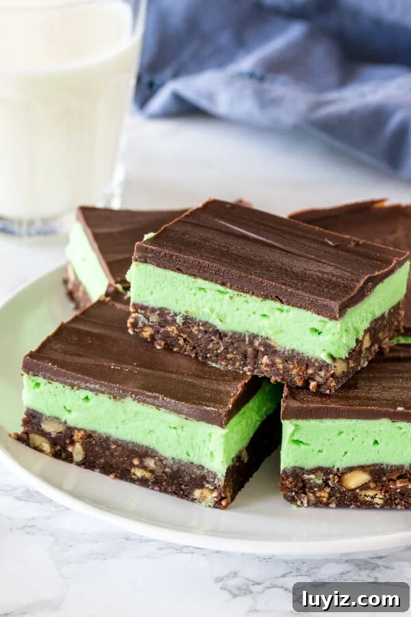 Mint Chocolate Nanaimo Bars Recipe — No-Bake Layered Treats 4 A plate of mint Nanaimo bars with a glass of milk.