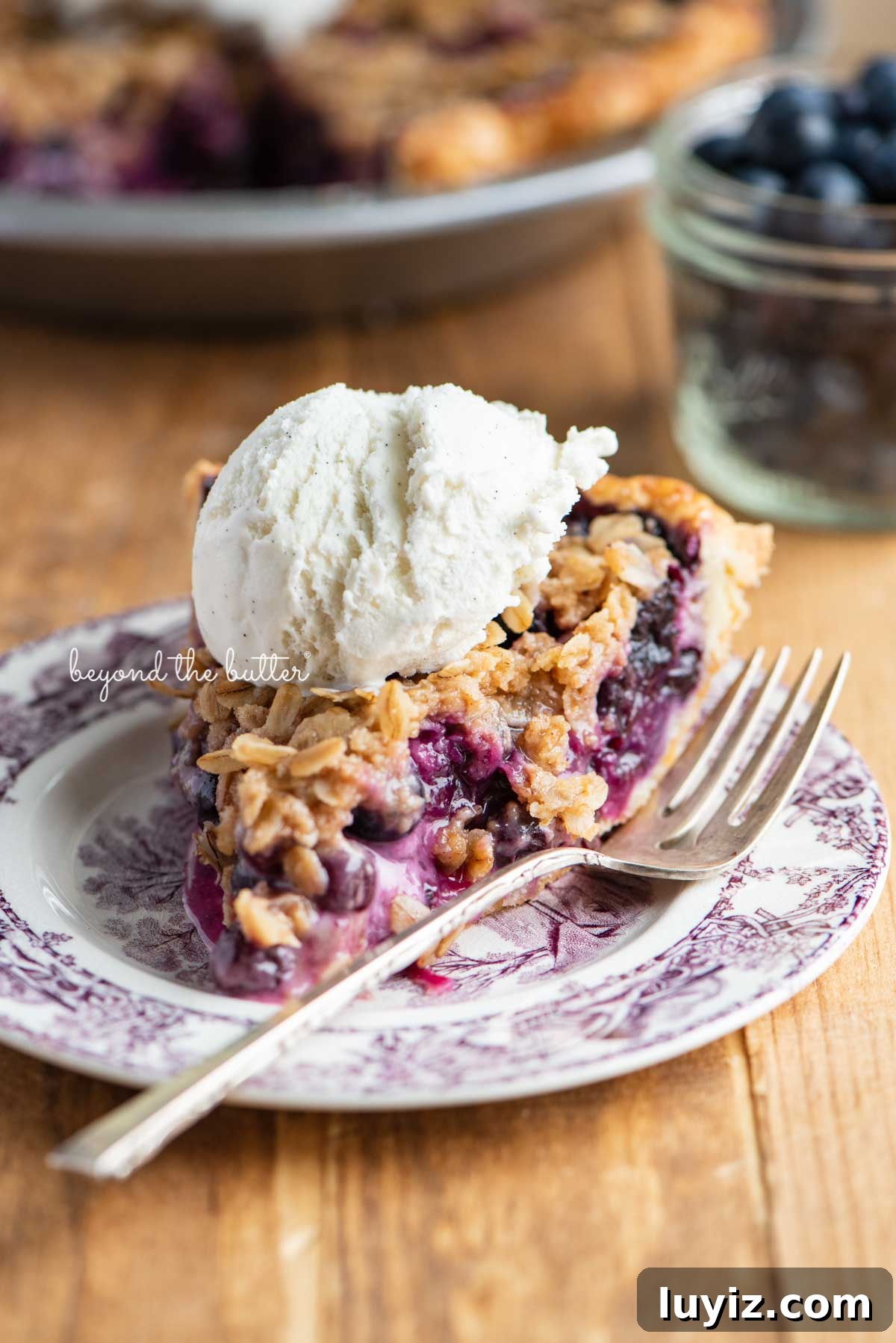 Blueberry Crumble Pie Recipe with Crunchy Oat Topping 7 Slice of blueberry crumble pie with scoop of vanilla bean ice cream on top