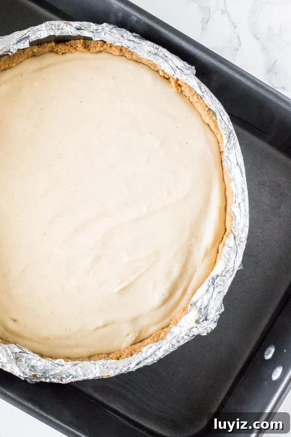 Decadent Pecan Pie Cheesecake Recipe: Rich Southern Dessert 6 Pecan pie cheesecake in water bath before baking.