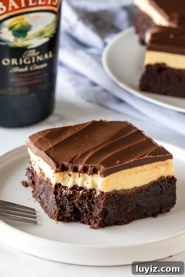 Decadent Baileys Irish Cream Chocolate Brownies 4 A Baileys brownie with a bite taken out of it to show the 3 layers and fudgy texture.