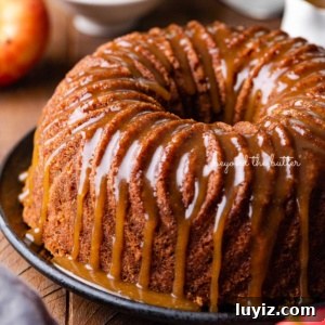 Moist Apple Bundt Cake with Cinnamon Glaze 13 Homemade apple bundt cake with brown sugar glaze surrounded by an apple and chef's knife on dark wood background.