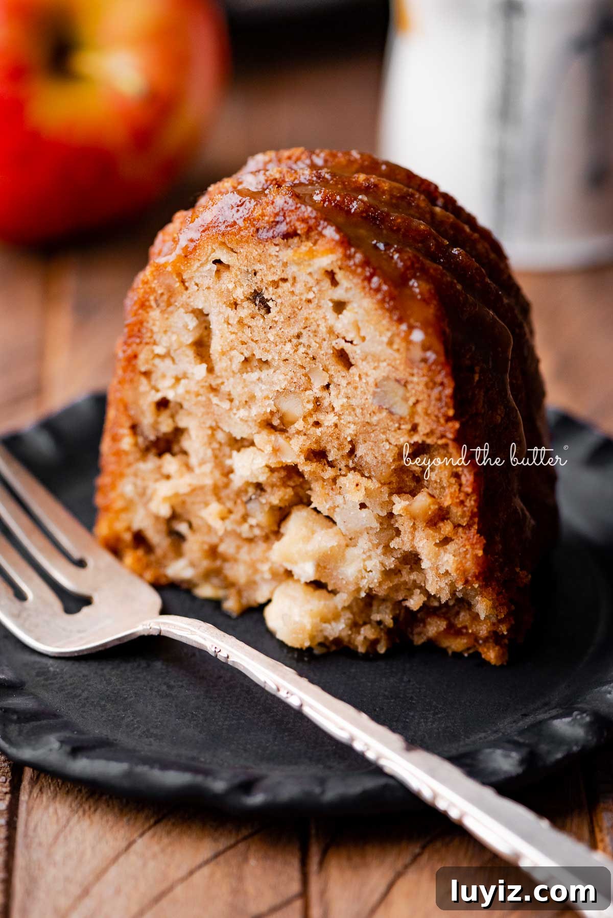 Moist Apple Bundt Cake with Cinnamon Glaze 3 Slice of homemade apple bundt cake on dark wood background | © Beyond the Butter®
