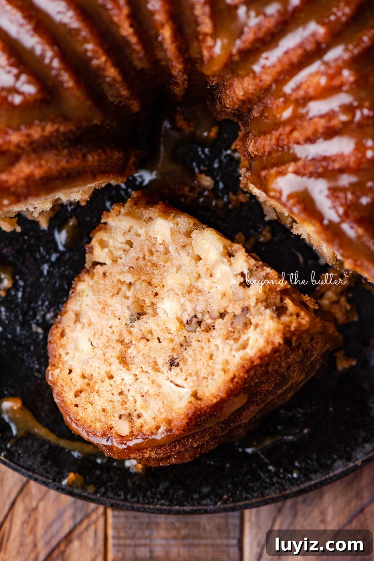 Moist Apple Bundt Cake with Cinnamon Glaze 5 Slice of homemade apple bundt cake on it's side on black plate | © Beyond the Butter®