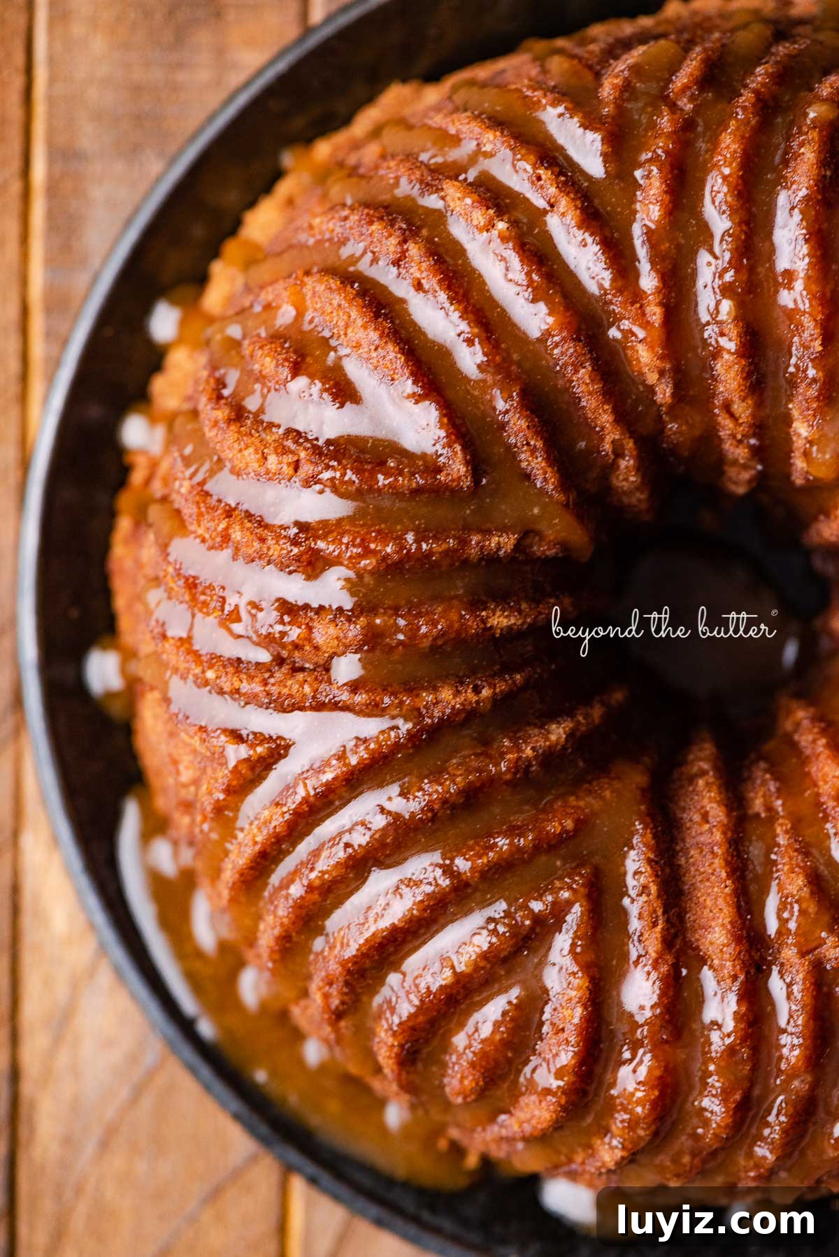 Moist Apple Bundt Cake with Cinnamon Glaze 6 Apple bundt cake on black dessert plate | © Beyond the Butter®