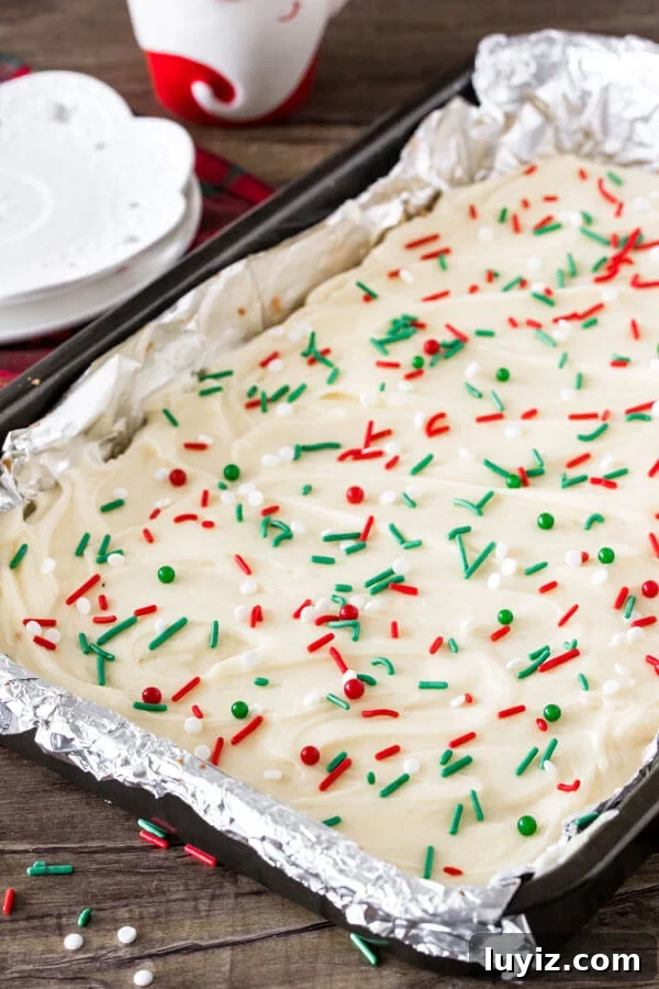 Christmas Sugar Cookie Bar Recipe — Festive, Soft & Chewy 3 A 9x13 inch pan of frosted Christmas cookie bars with sprinkles.