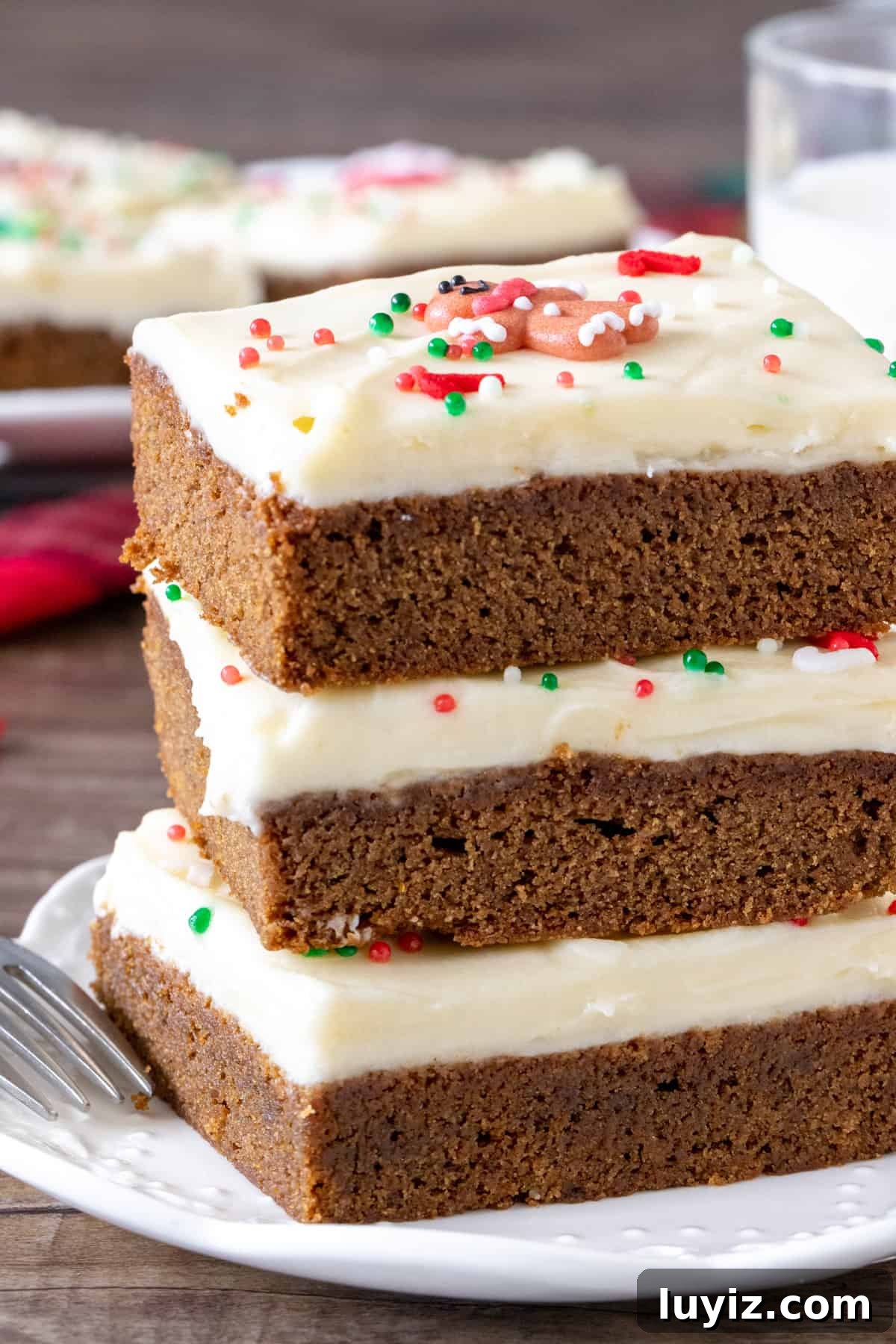 Chewy Gingerbread Cookie Bars with Spiced Molasses Glaze 4 Stack of 3 cookie bars topped with frosting and sprinkles