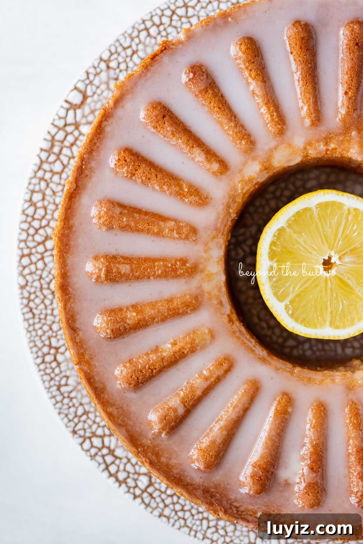 Lemon Cream Cheese Pound Cake Recipe with Zesty Glaze 7 Glazed lemon cream cheese pound cake on a ceramic cake stand