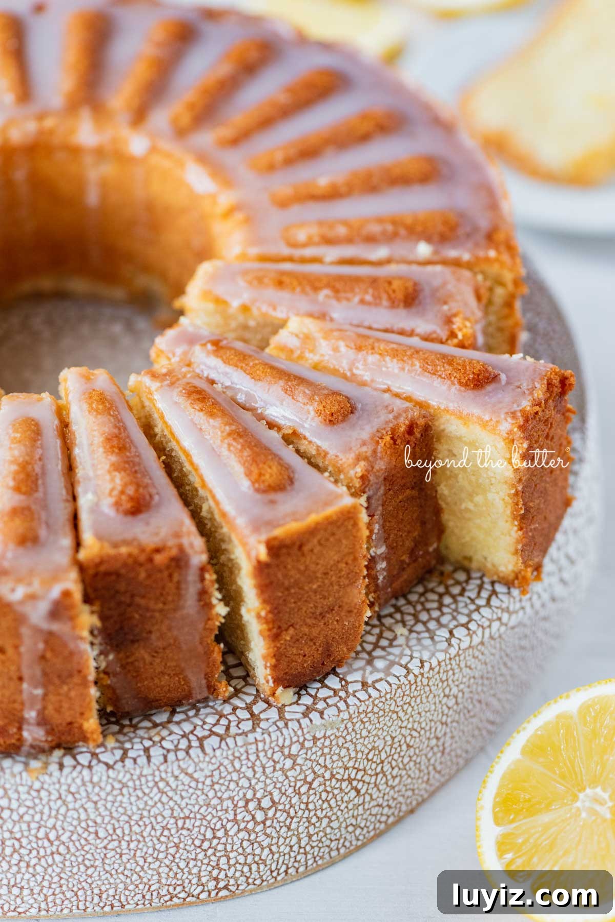 Lemon Cream Cheese Pound Cake Recipe with Zesty Glaze 9 Sliced lemon cream cheese pound cake on a cake stand